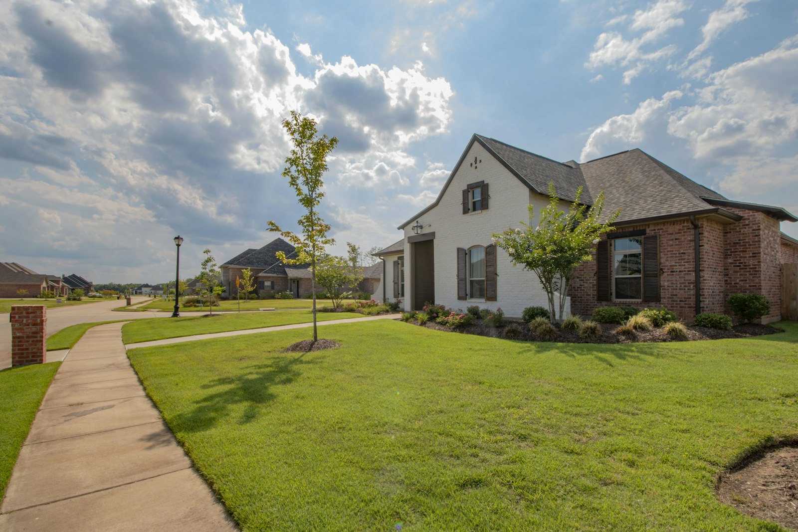 Suburban home and lawn under a big sky